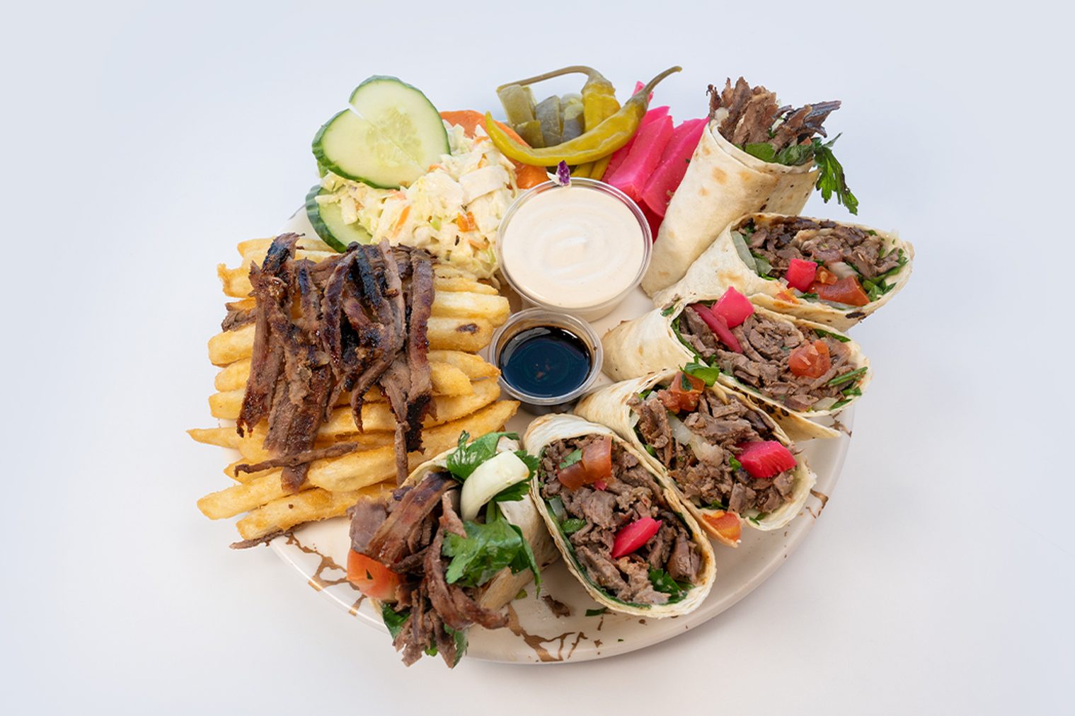 Savor the richness of Anas Beef Shawarma Meal. Enjoy tender beef, pickles, tomatoes, parsley, onions, pomegranate molasses, and tahini sauce, accompanied by fries, coleslaw, pickles, turnip, and chilli pepper. Explore our menu for a hearty shawarma feast!